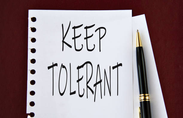 istock KEEP TOLERANT - words on a white sheet on a brown background with a pen 2170342320