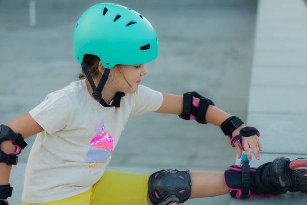 istock Beautiful playful school girl with protective equipment and helmet on inline rollerblade skates in public park near the corporate building. 2170342716