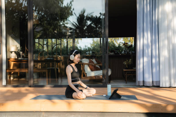 istock Asian woman doing yoga at home 2170345155