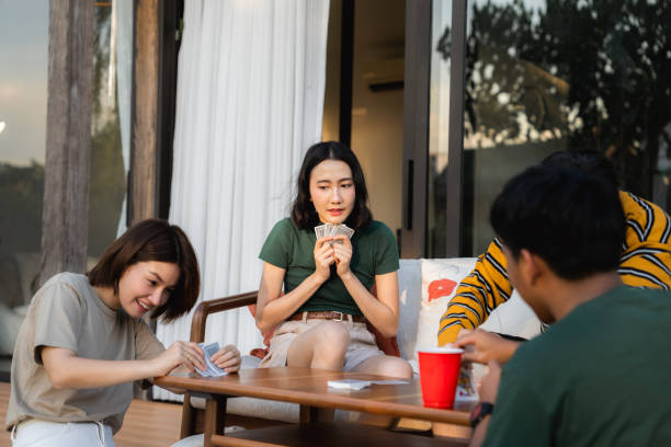 istock Group of friends enjoying conversation while dealing cards to begin playing poker game 2170345275