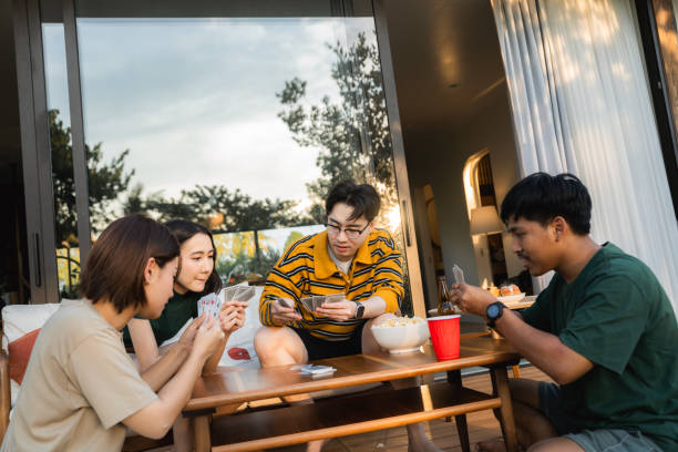 istock Group of friends enjoying conversation while dealing cards to begin playing poker game 2170345458