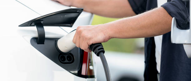 istock Man recharging battery for electric car during road trip. Exalt 2170347258