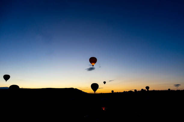Hot air balloons rise before the sun rises