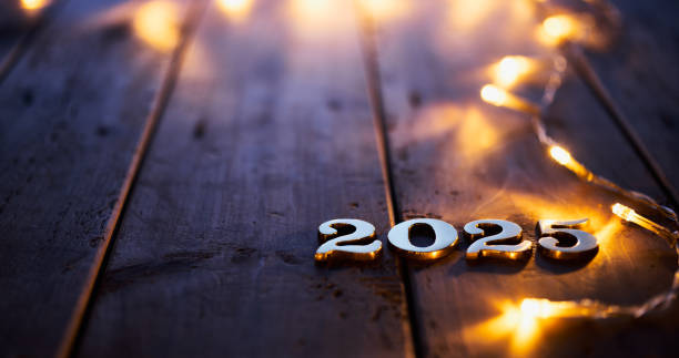 istock Festive New Year 2025 celebration concept with glowing string lights on a rustic wooden table 2170348438