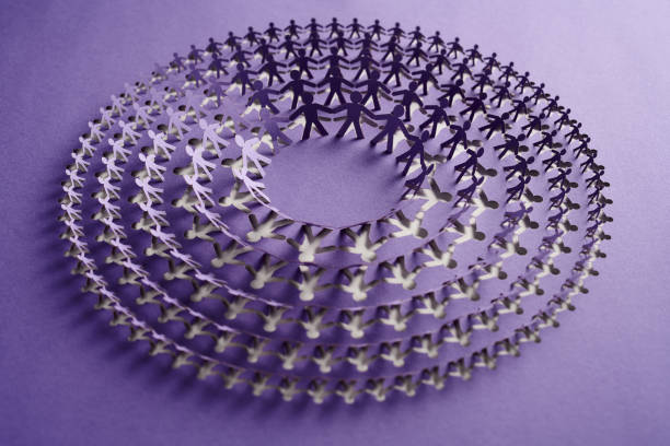 istock Circular paper cut artwork featuring interconnected human chain design on purple background 2170348704