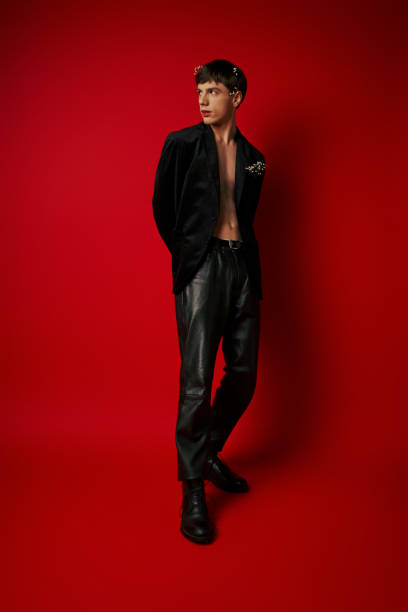 istock Romantic and stylish young man exudes charm in bold red studio setting 2170350467
