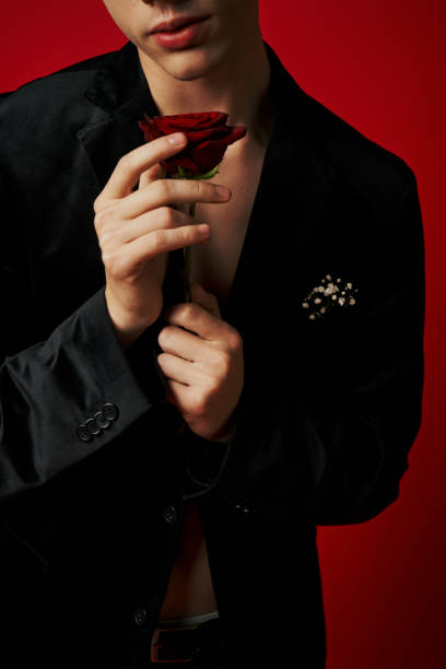 istock A stylish young man expresses love with a rose in a vibrant studio setting 2170351078