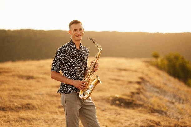 istock A remarkably talented young saxophonist is enjoying a peaceful and serene sunset on a beautiful landscape backdrop 2170351350