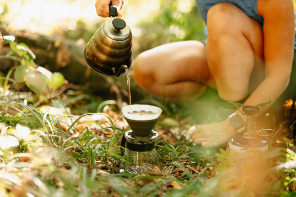 I am savoring the delightful tranquility of nature while skillfully brewing a fresh cup of coffee outdoors