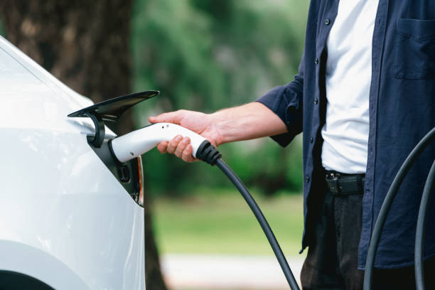 istock Man recharging battery for electric car during road trip. Exalt 2170357495