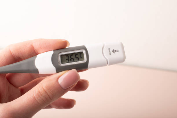 istock Womans hand holding thermometer that shows normal human temperature. Measuring body temperature. Health check. Health care concept. High quality photo 2170358617