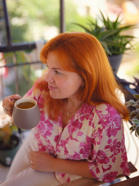 istock Woman drinking tea at the balcony 2170367500