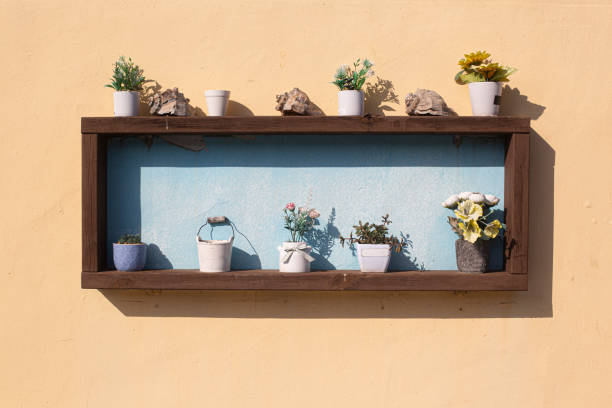 Mini flower pot on background yellow colored concrete wall.
