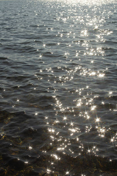 istock reflection sparkles on tiny ripples of sea water wave background, top view. 2170378469