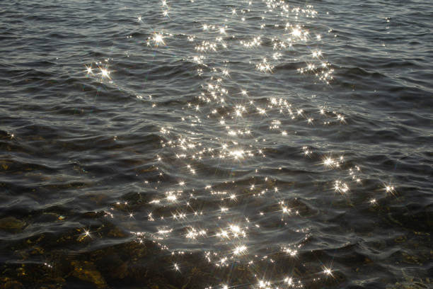 istock reflection sparkles on tiny ripples of sea water wave background, top view. 2170378856