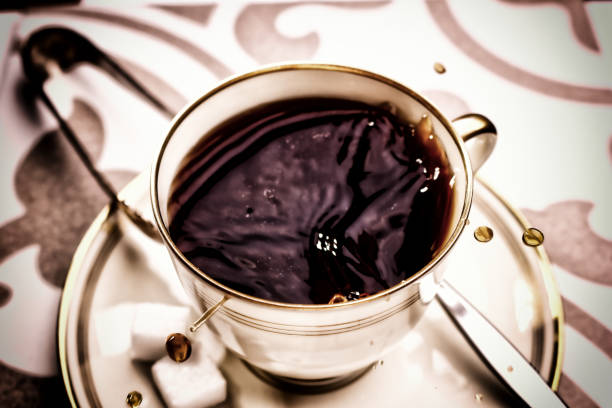 Two golden cups of hot coffee with steam on black background, 3d illustration