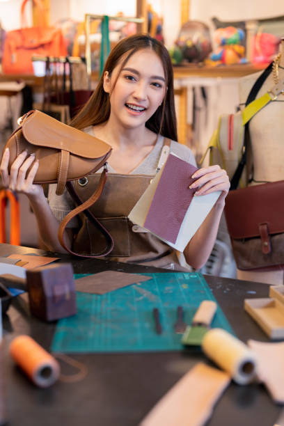 istock Leather studio craftman asian artisan working with leather bags part while gluing piece bag handle,The process of gluing leather tanned leather craft materials by a craftsman 2170379898