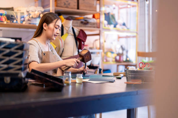 istock Leather studio craftman asian artisan working with leather bags part while gluing piece bag handle,The process of gluing leather tanned leather craft materials by a craftsman 2170379950