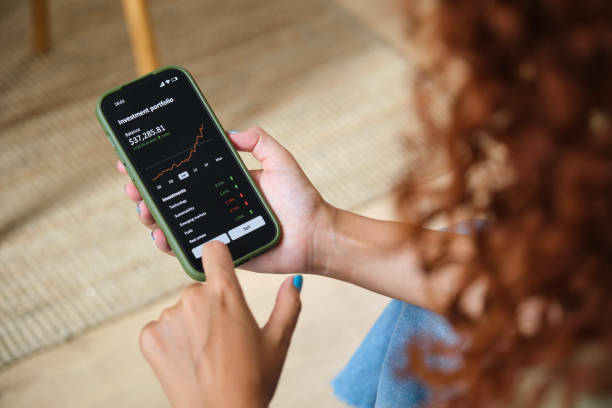 istock Woman managing finances using investment app on smartphone 2170383436
