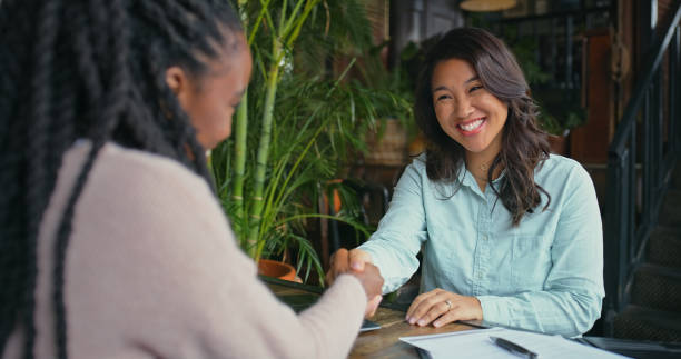 istock Happy woman, handshake and interview with documents at cafe for hiring, recruiting or partnership at restaurant. Female person, employer and candidate shaking hands for career deal or job opportunity 2170384517