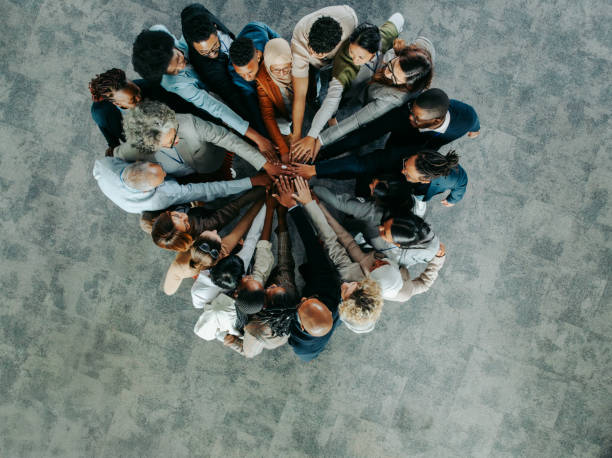 istock Group of diverse business colleagues showing teamwork in an office setting from above 2170385149