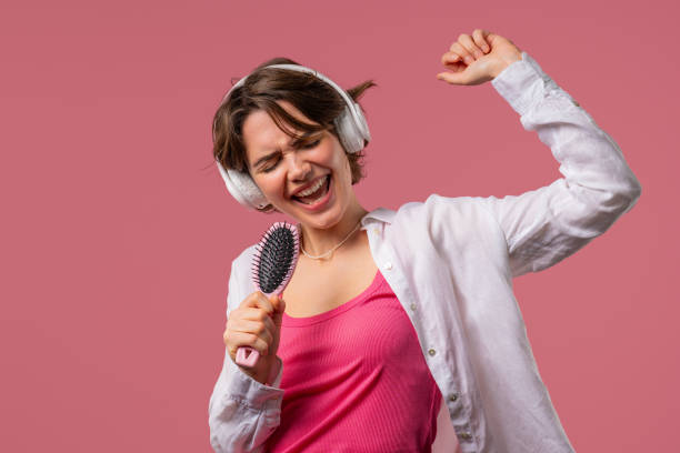 istock Woman singing, dancing with hair brush instead microphone on pink background 2170385684