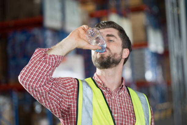 istock Worker drinking water. Male worker drinking water after break time in warehouse 2170386661