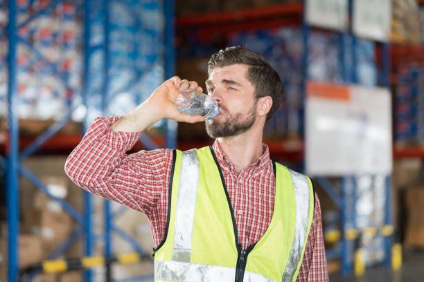 istock Worker drinking water. Male worker drinking water after break time in warehouse 2170386671