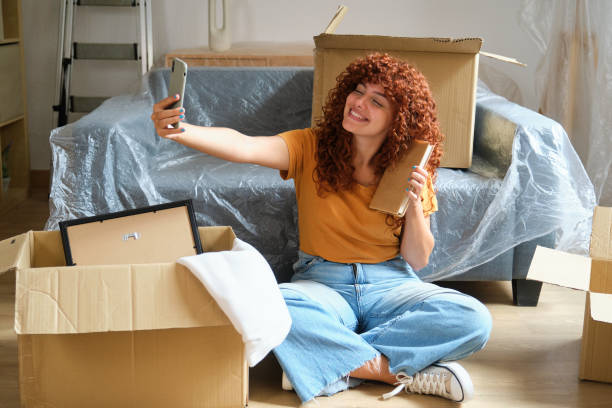 istock Happy woman taking selfie while moving into new apartment 2170387468