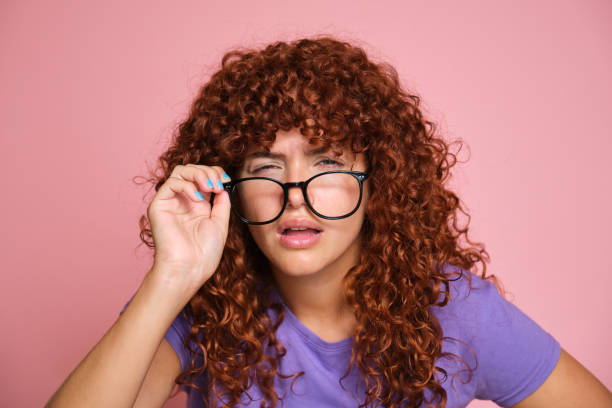 istock Confused redhead woman looking over glasses with skeptical expression or vision problem 2170388897