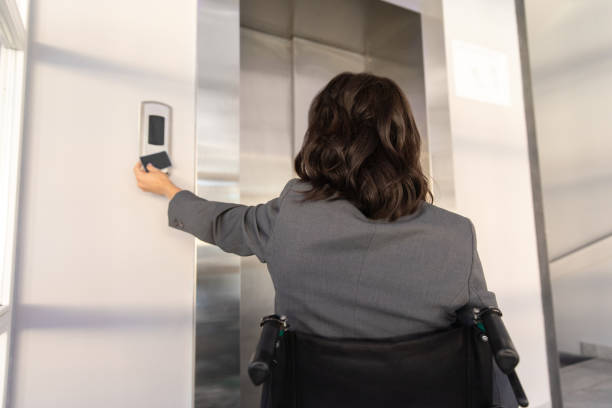 istock Female entrepreneur with disabilities in wheel chair waiting for elevator in office at work 2170390519
