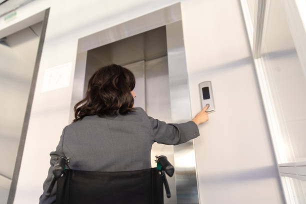 istock Female entrepreneur with disabilities in wheel chair waiting for elevator in office at work 2170390536