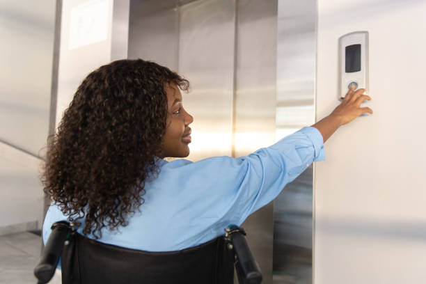istock Female entrepreneur with disabilities in wheel chair waiting for elevator in office at work 2170390594