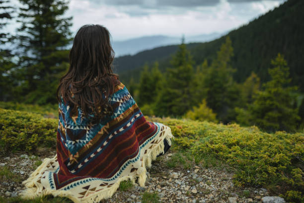 istock Woman with poncho meditating in the mountain 2170390885