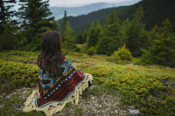 istock Woman with poncho meditating in the mountain 2170390886