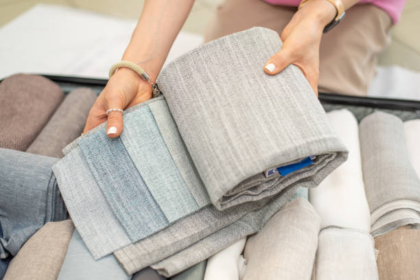 istock The girl puts samples of fabrics in a suitcase. 2170391714