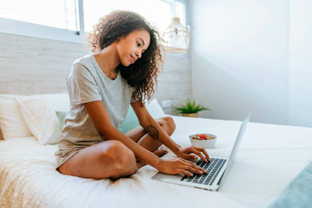 istock Woman using laptop in bed in the morning 2170394132