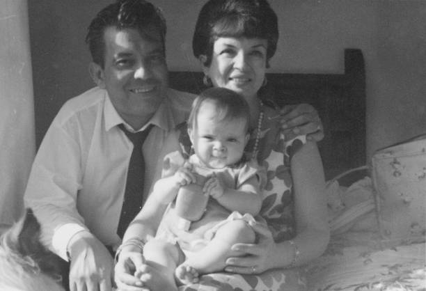 snímek pořízený v roce 1960, usmívající se starší pár pózující držící svou vnučku v jejím domě - vytváření pouta fotky - stock snímky, obrázky a fotky