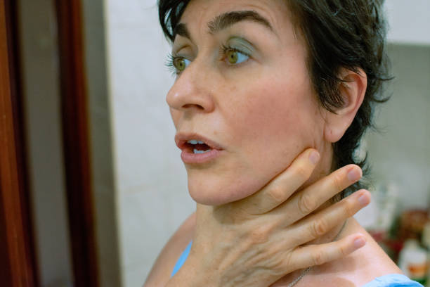 beautiful natural middle-aged woman looking at her face, showing emotions while looking at her face