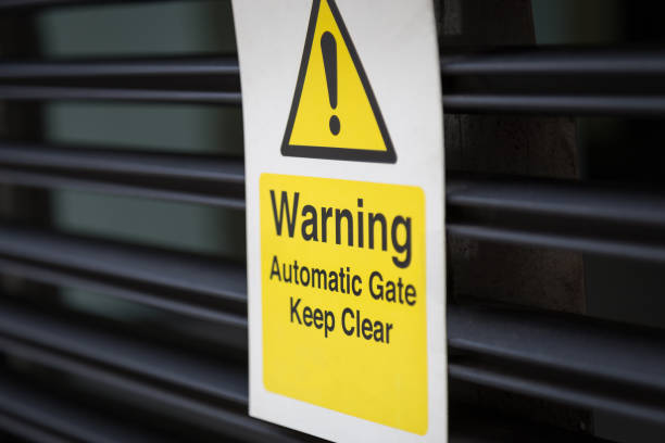 istock An angled perspective of a warning sign on a black metal door front shutter with leading lines pattern. 2170397798