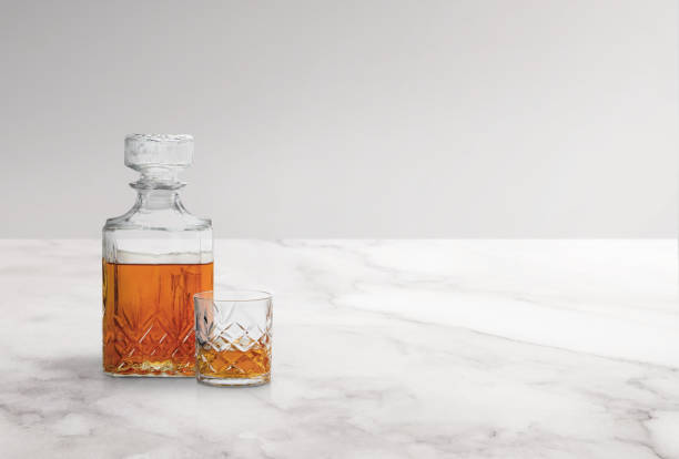 istock Glass and bottle of whiskey on a white marble 2170397934