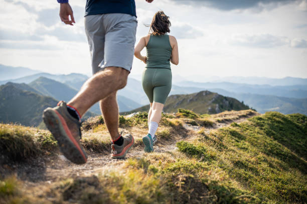istock Couple trail running in mountain at sunset. 2170402425