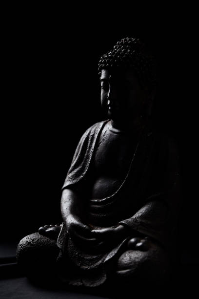 istock Meditating Buddha Statue on dark background. Close up. Copy space. 2170403777