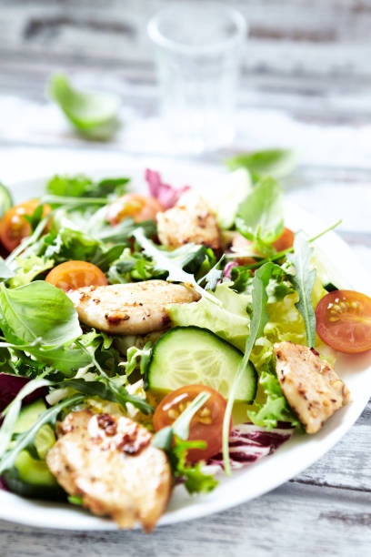 istock Salad with Chicken Breast, Cherry Tomatoes, Cucumber, Rocket and fresh Basil. Bright wooden background. Close up. 2170404119
