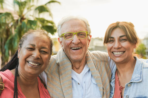 istock Happy elderly people smiling on camera with city in background during fall time - Joyful senior friendship 2170404311