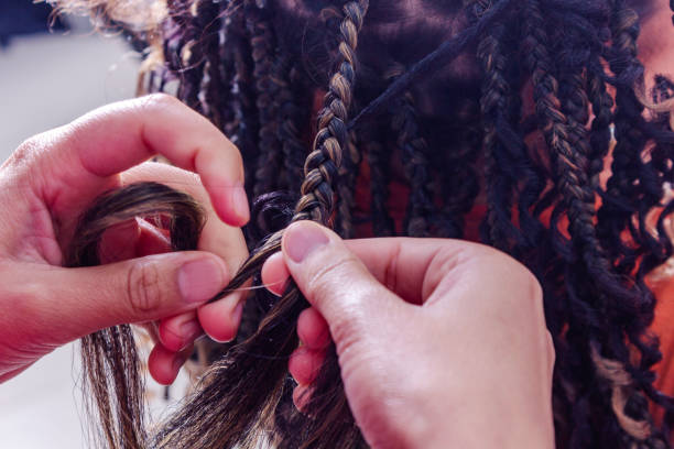 istock Professional braider stretching hair by applying natural braids 2170405666