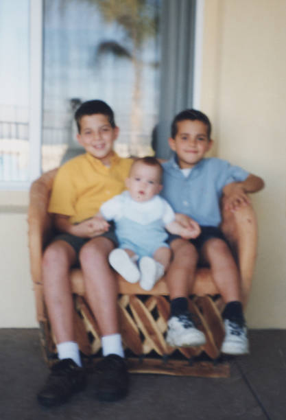 istock Three boys siblings sitting at their home backyard looking at the camera 2170405778