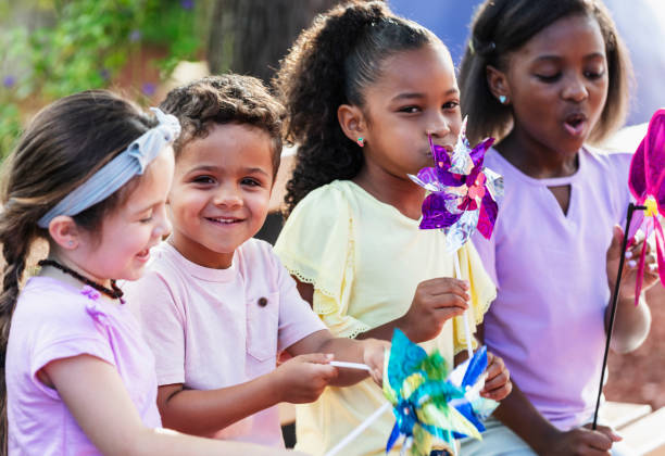istock Multiracial children in park playing with pinwheels 2170407735
