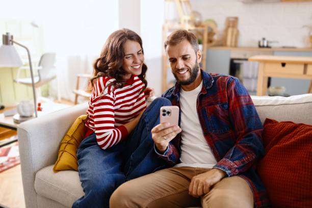istock Smiling couple using online payments on smartphone 2170409714