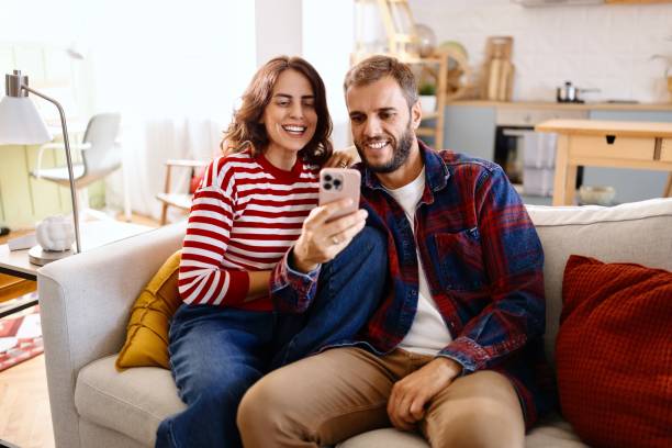 istock Smiling couple using online payments on smartphone 2170410224